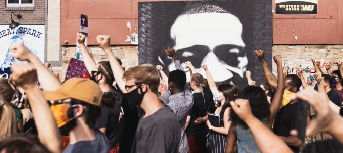 A June 2020 protest in Minneapolis with a portrait of Floyd by Peyton Scott Russell in the background. Lorie Shaull/Flickr.