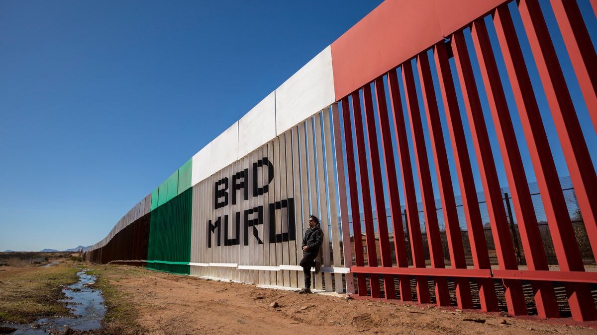 Man standing on Mexican side of the border wall