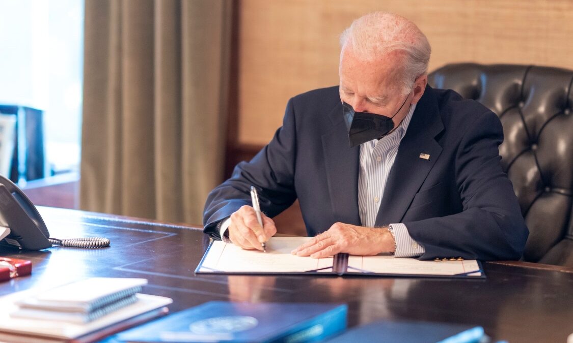 Biden signing bill at desk