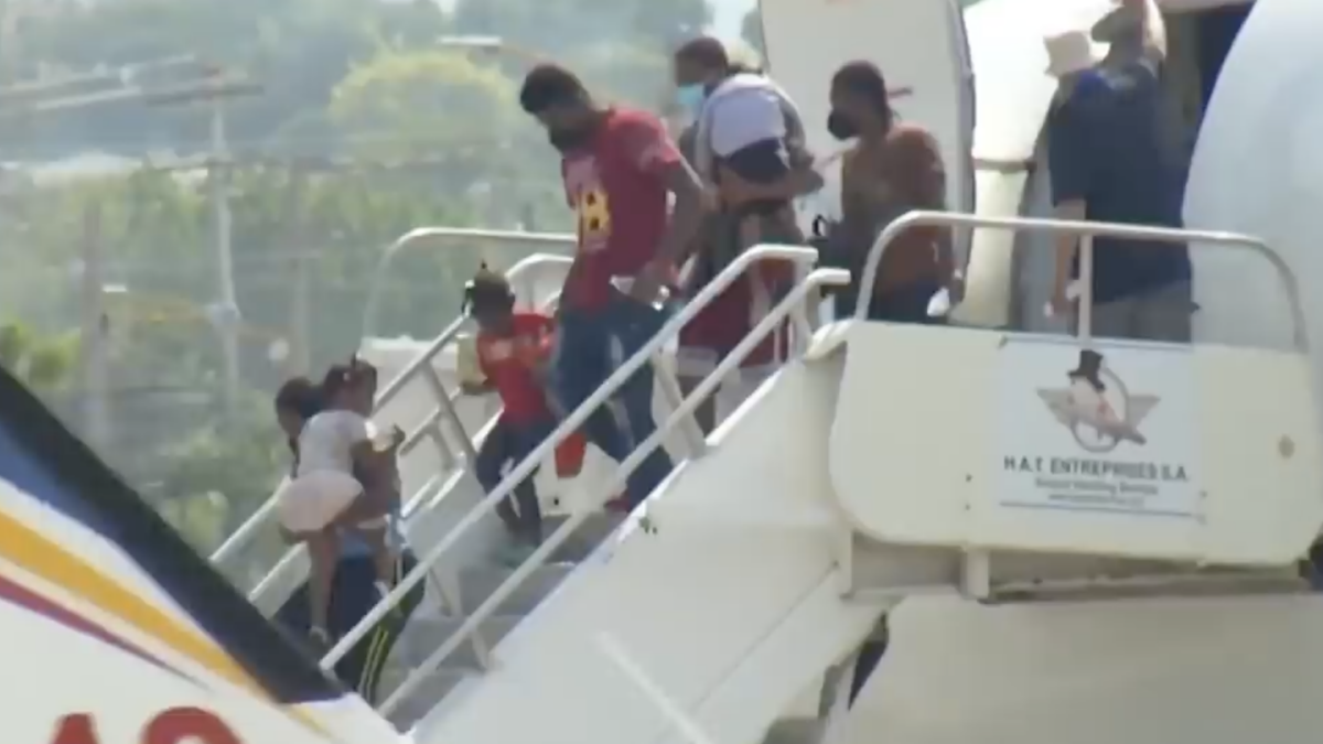Migrants getting off plane