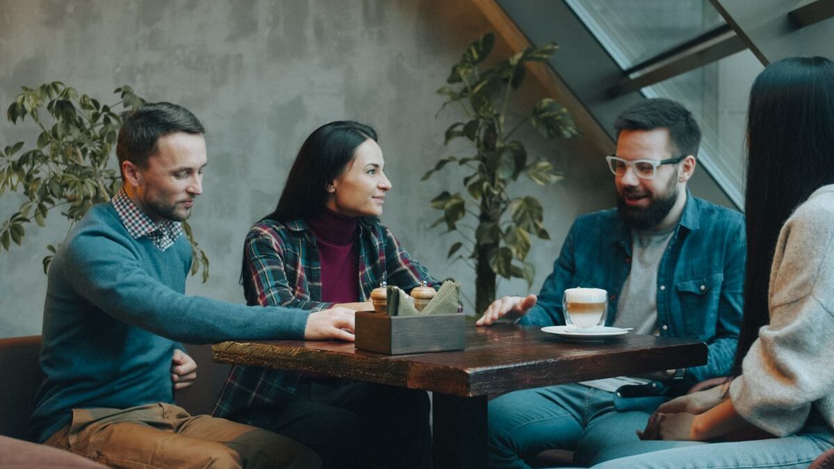 Four people having a conversation at a coffee shop