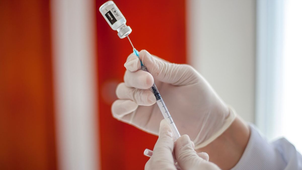 Person preparing vaccine syringe