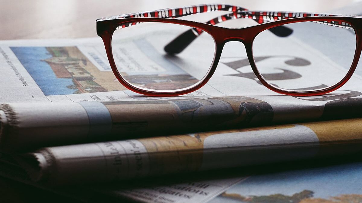 Glasses on a stack of newspapers