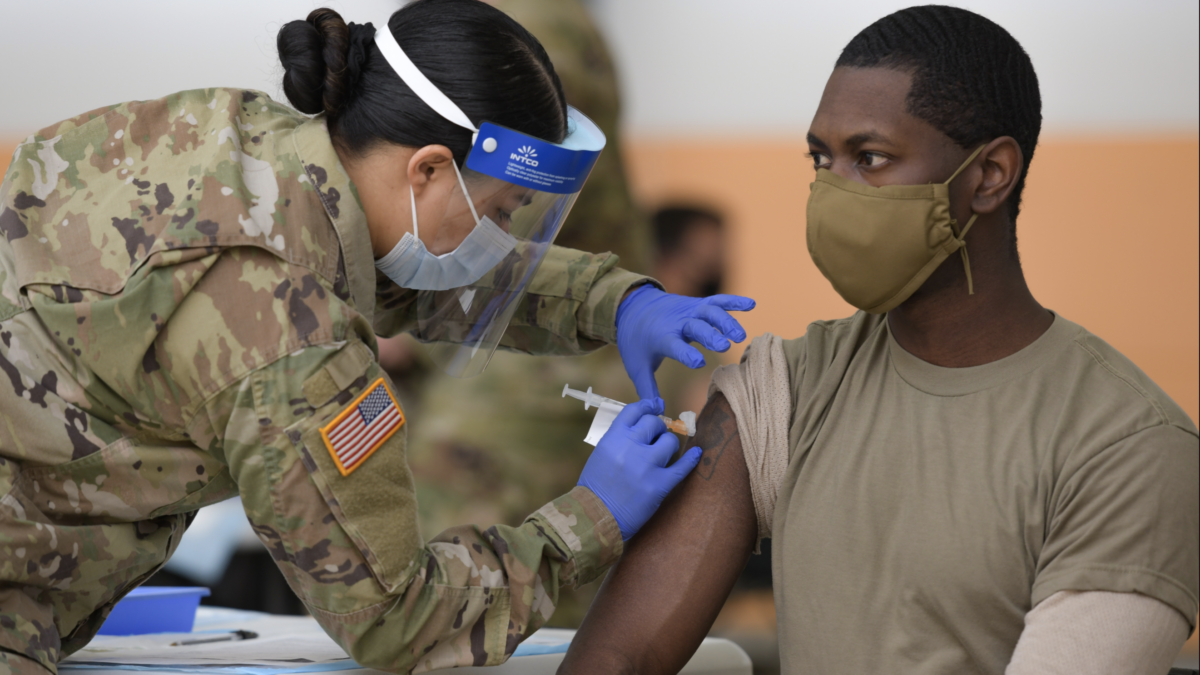 woman administers vaccine to army serviceman