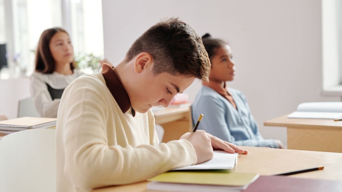 Student writing in a notebook,
