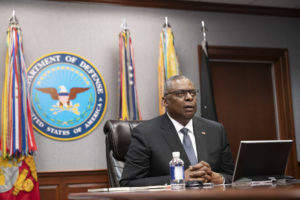 Secretary of Defense sits behind desk