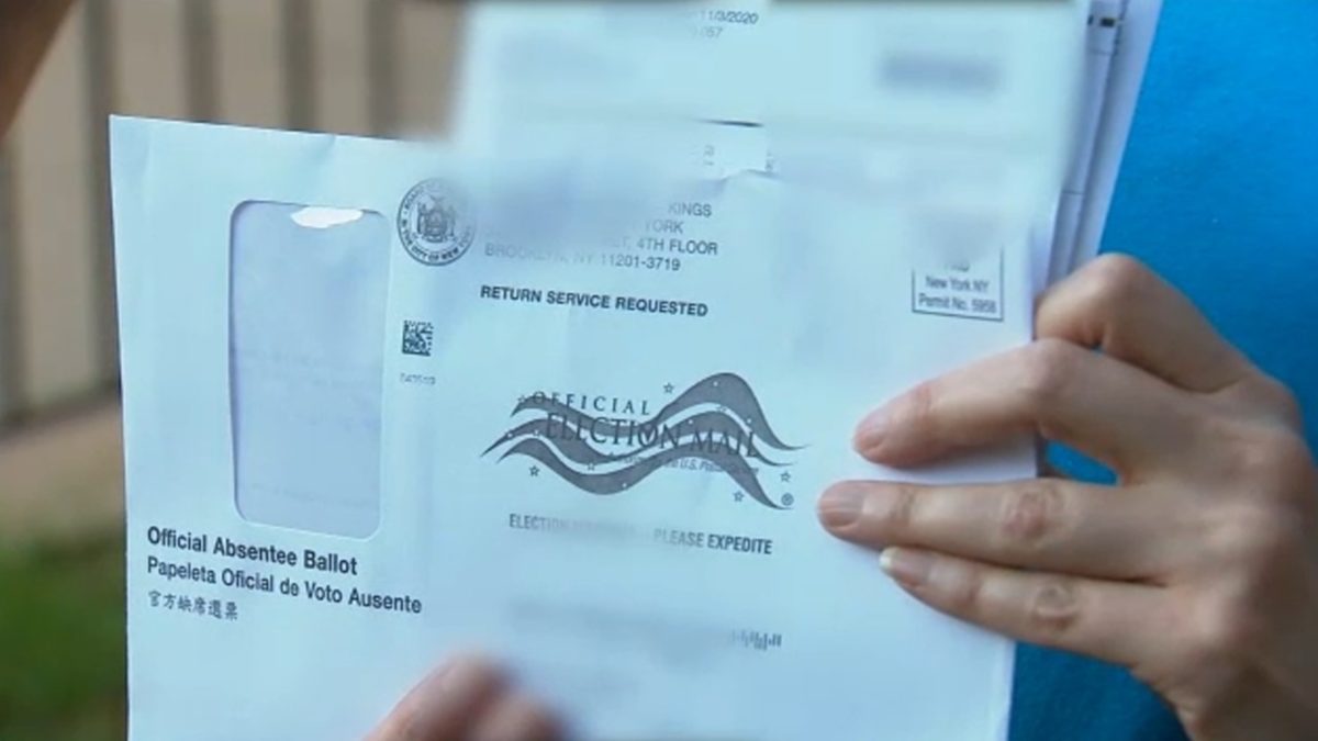 hands holding paper mail in ballot