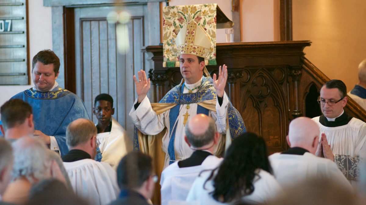 Bishop Steven J. Lopes raises hands at St John