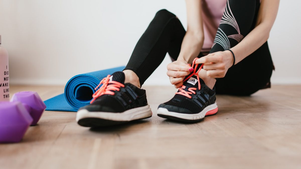 woman tying her shoes before working out