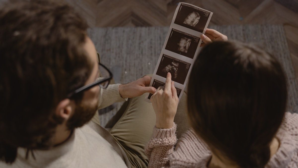 couple looks at sonogram of baby