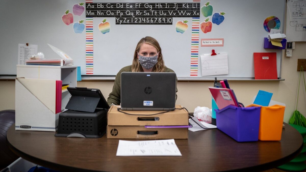 Teacher with mask teaching virtually