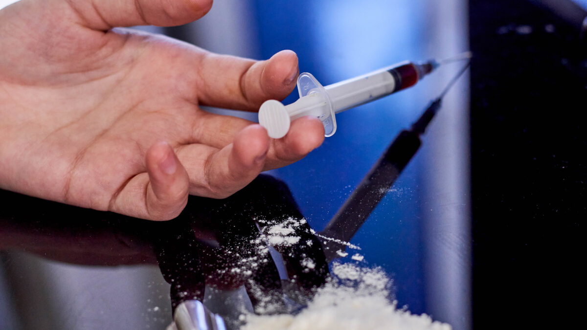 Hand with syringe and powder
