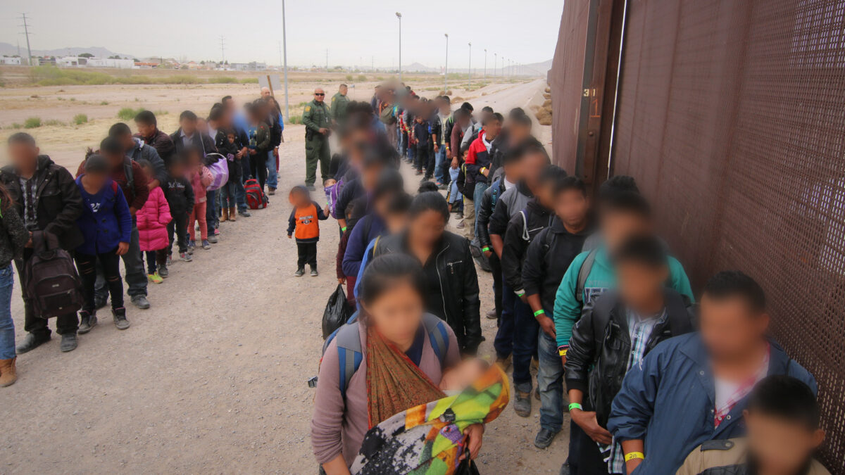 Border crisis migrants stand in a line