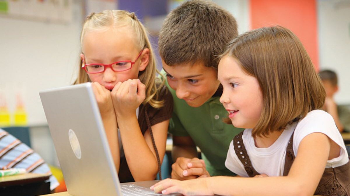 schoolchildren looking at laptop