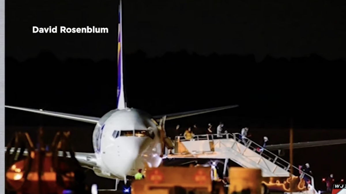 people deplaning airplane at night