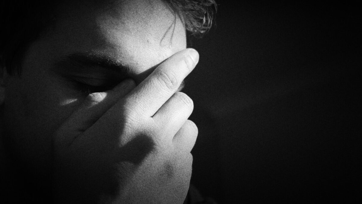 Man in despair holding his face in his hand