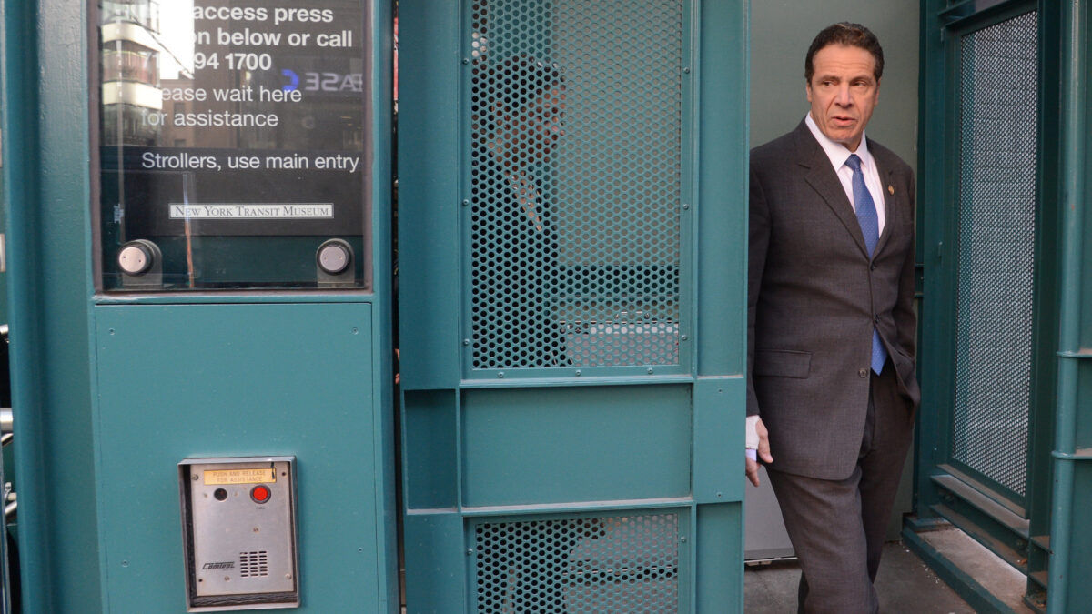 Andrew Cuomo walks out of a doorway