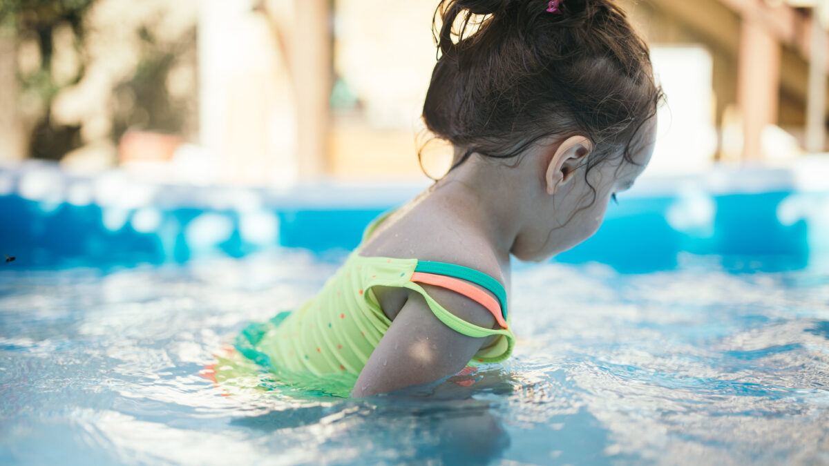 little girl playing in swimming pool