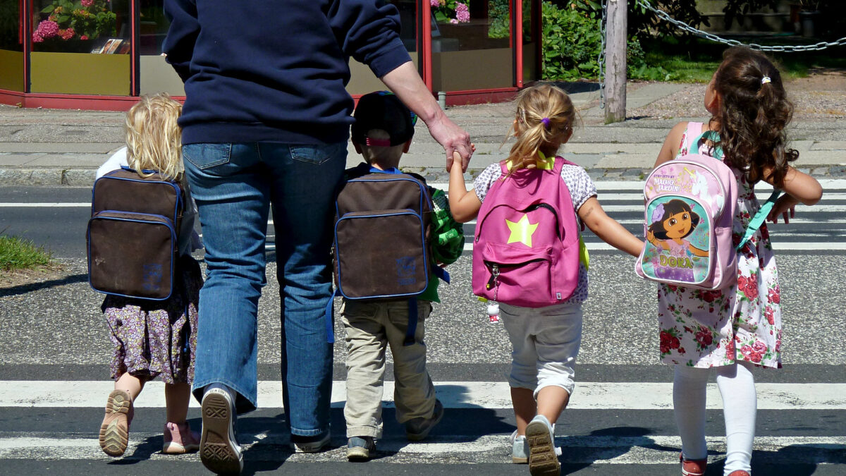 adult with kids wearing backpacks
