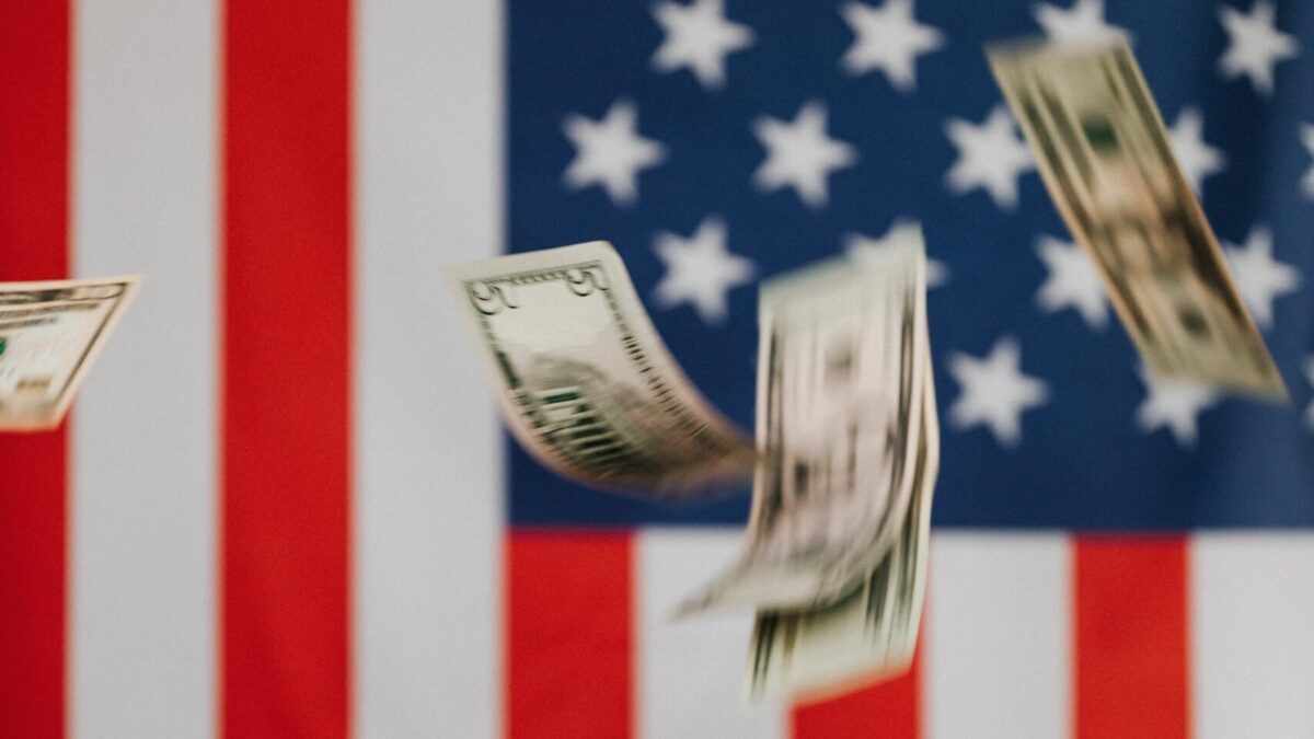 money falling in front of an American flag