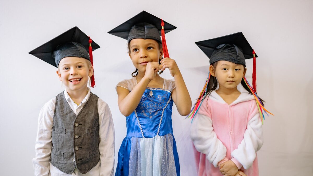 three kids with graduation caps