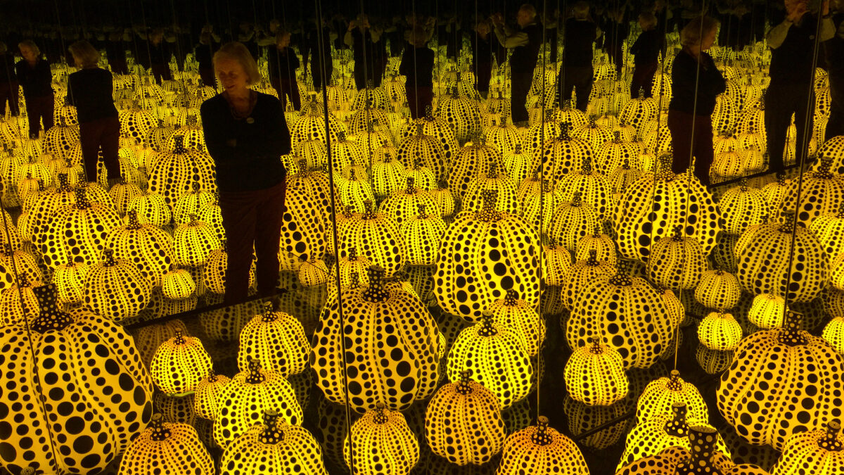 man standing in Japanese pumpkin art exhibit