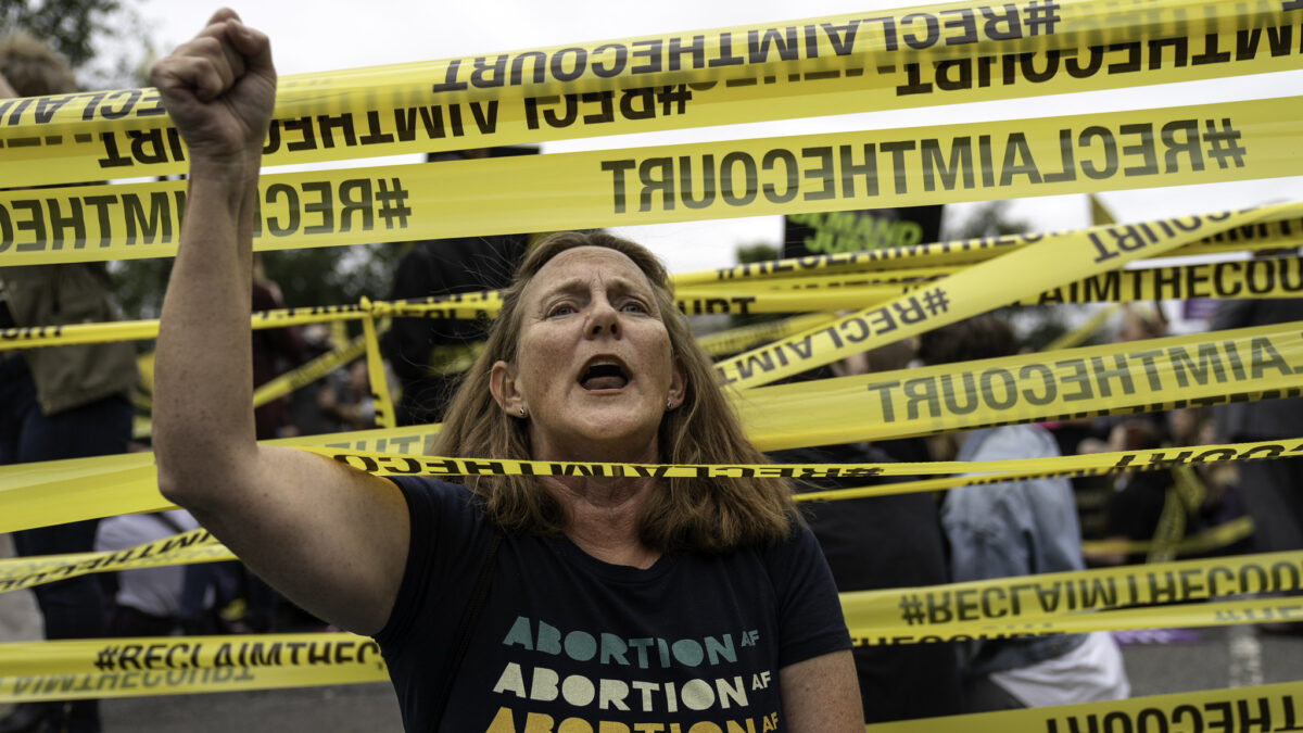 abortion activist protesting amid yellow tape