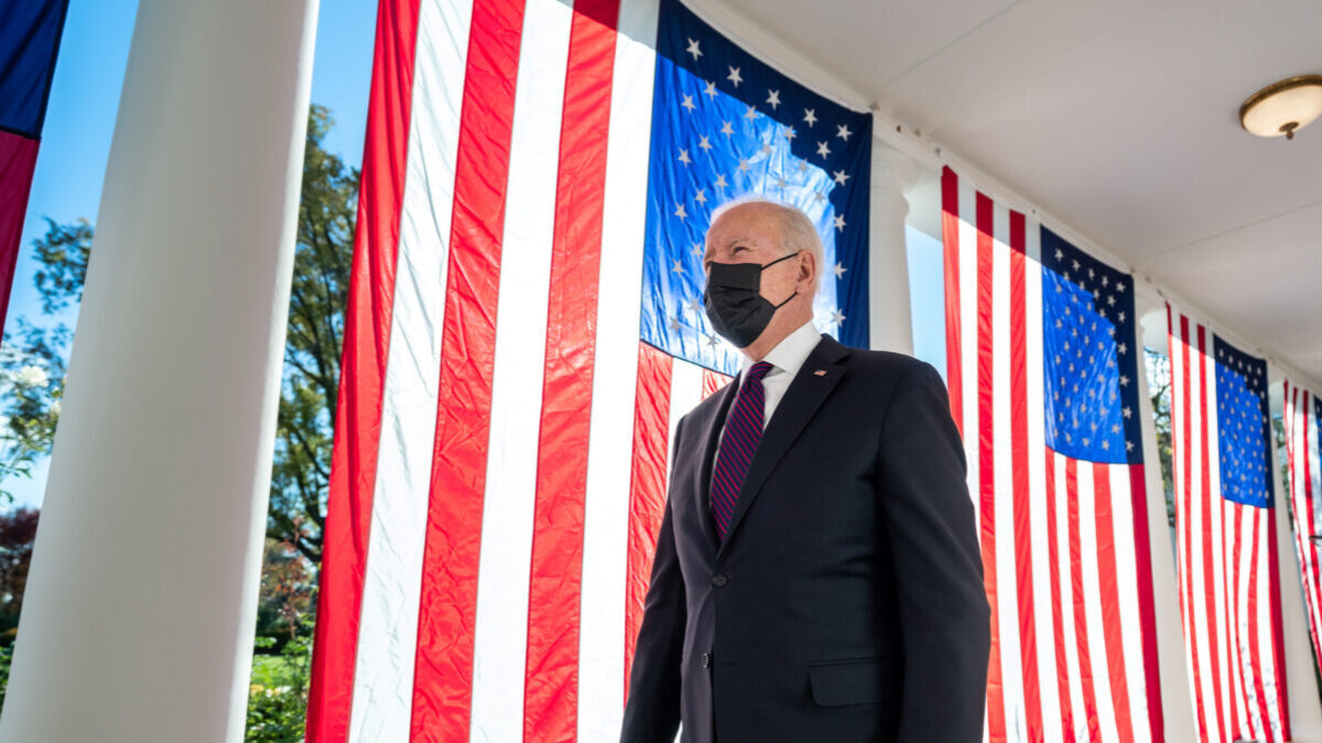 President Joe Biden walks past U.S. flags