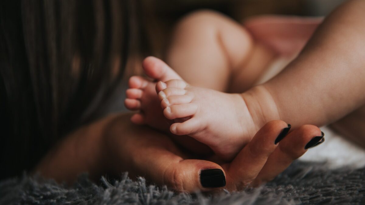 Baby's feet cradled in mother's hand