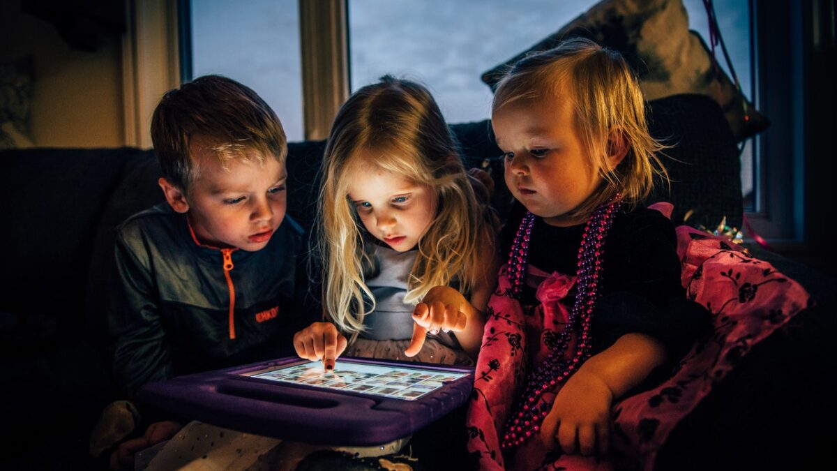 three children glaring at tablet