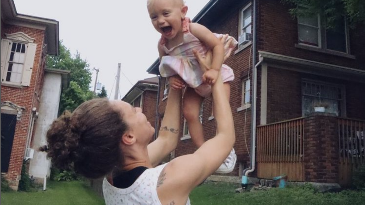 woman tossing baby in air