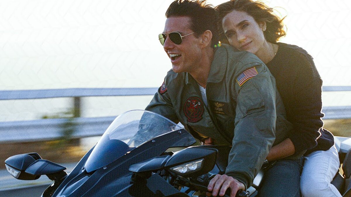 Tom Cruise driving motorcycle with chick on his back