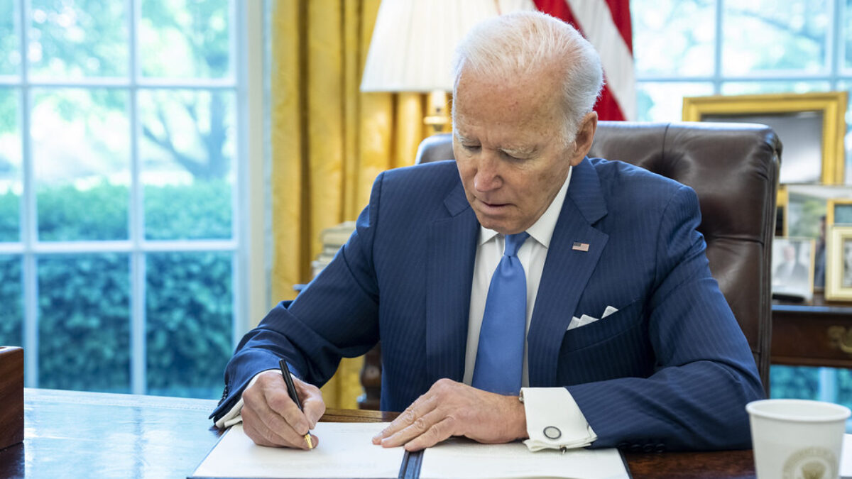 President Joe Biden signs a letter to Speaker of the House Nancy Pelosi, D-Calif