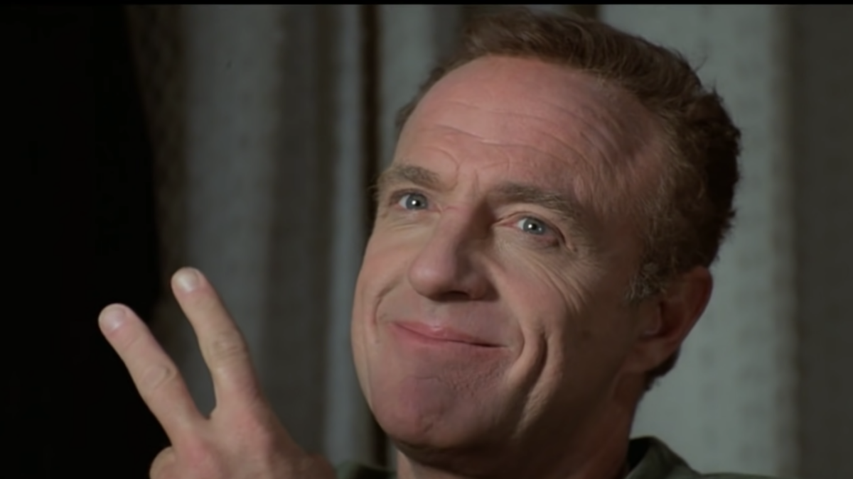actor james caan on screen in film holding up fingers