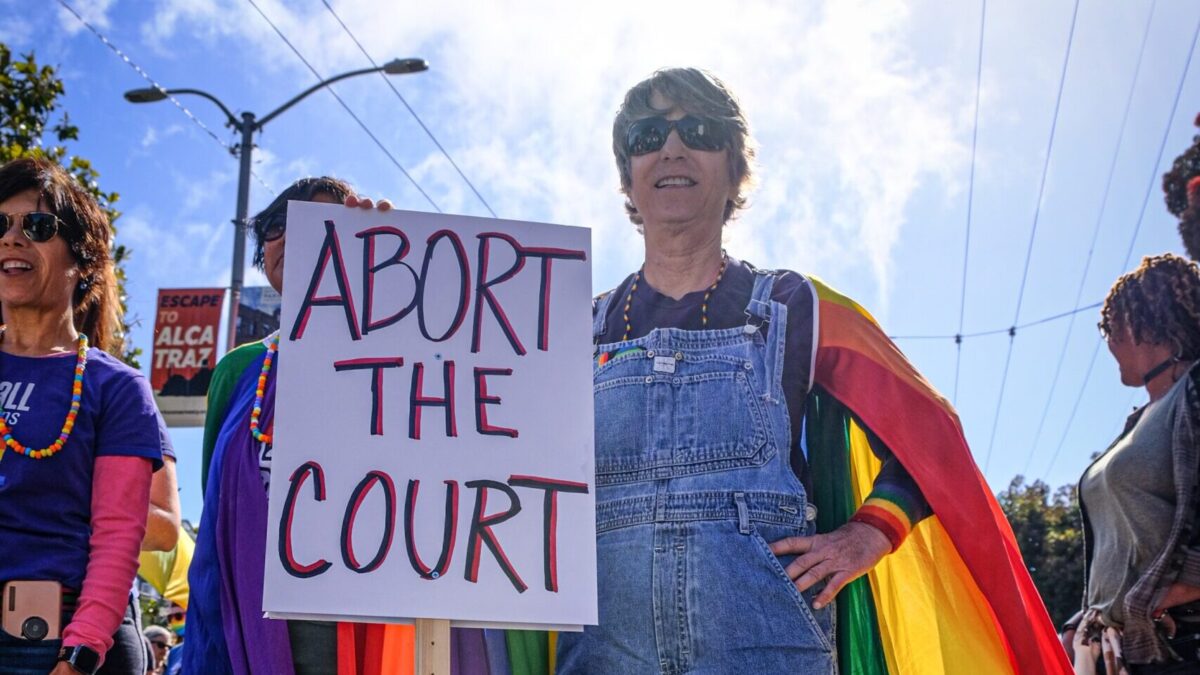 lady holding “abort the court” sign