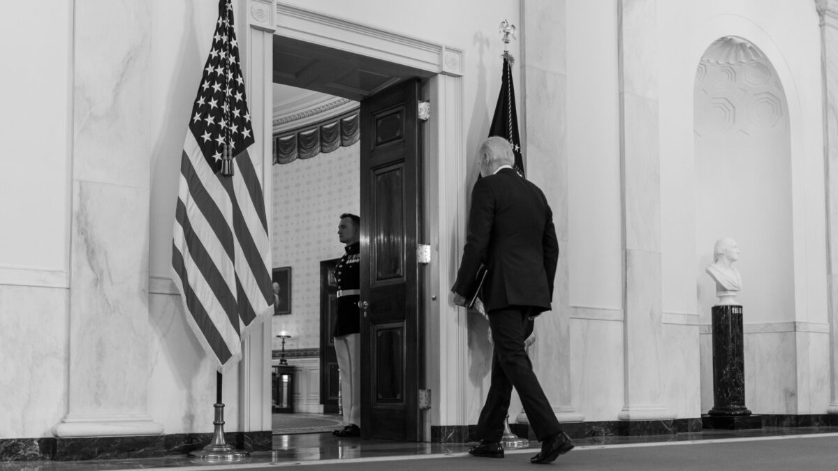 Biden walks through a door with his back turned