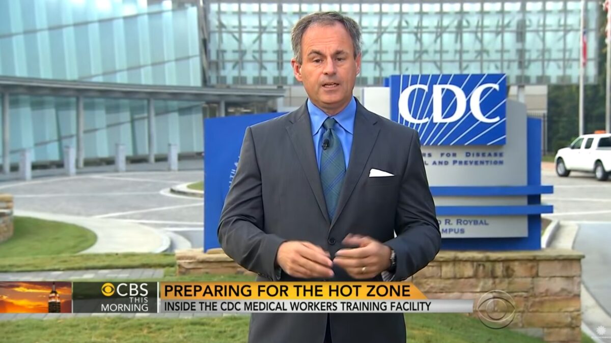 News anchor standing in front of the CDC building