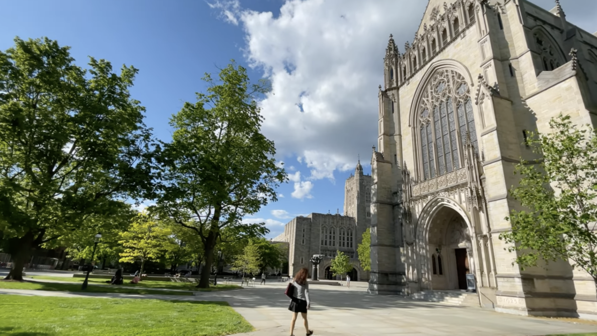 woman walking on campus of princeton university in front of big buidlings