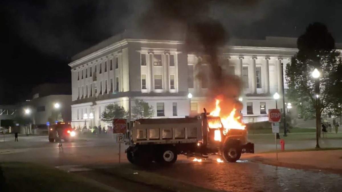 truck burning in front of building at night