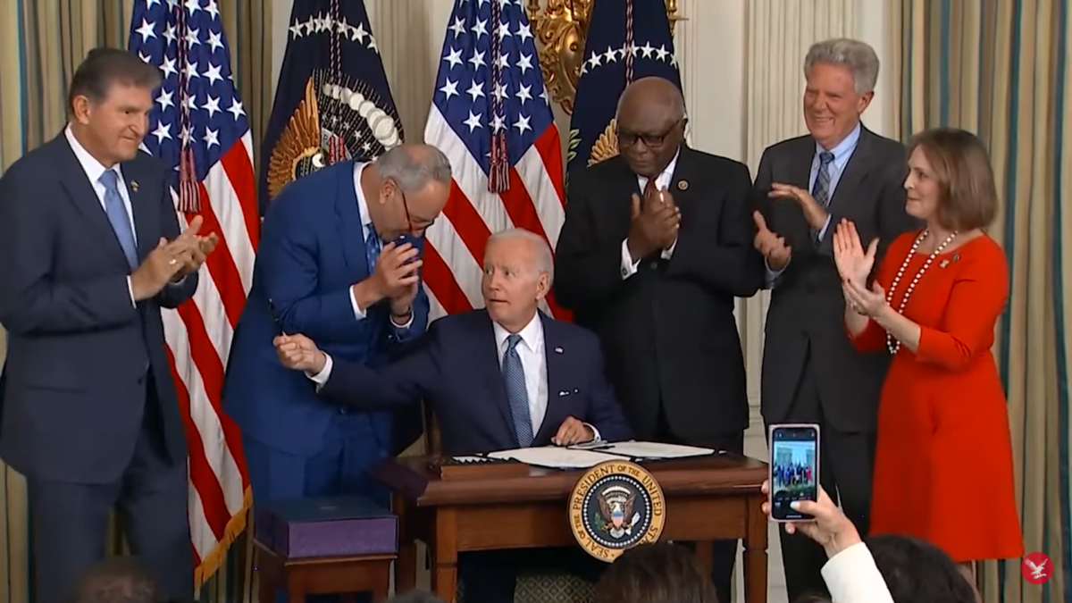 Joe Biden hands pen to Joe Manchin