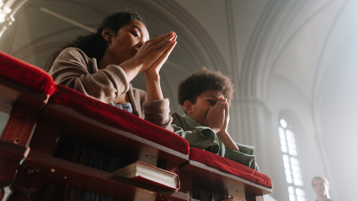 woman praying with her son in church
