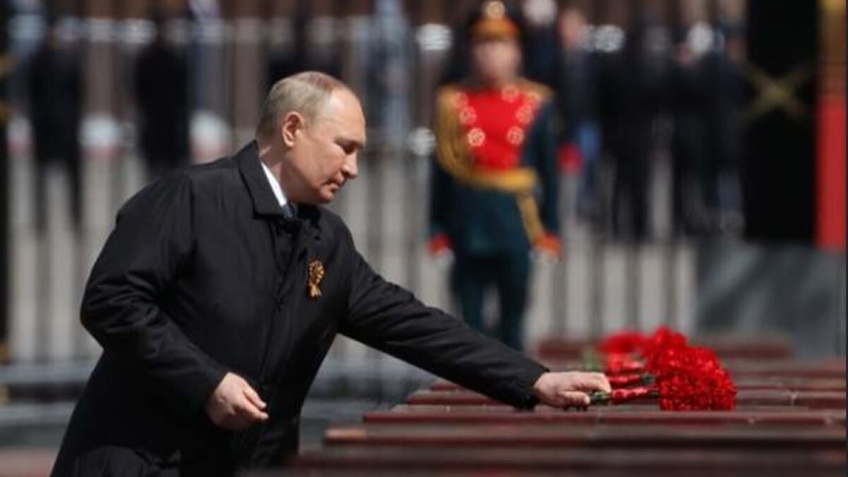 Vladimir Putin laying a rose on a casket