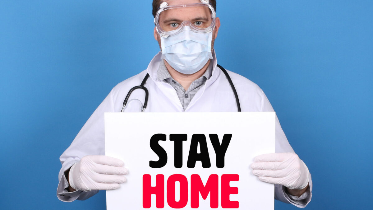 doctor holds stay home sign during covid lockdowns