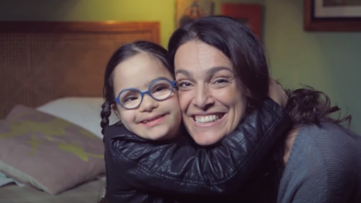Little girl with Down Syndrome hugs her mom in a scene from 'Dear Future Mom'