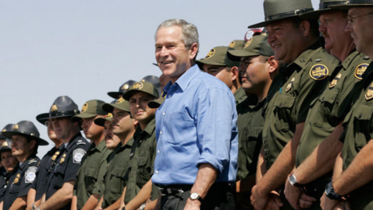 George Bush standing in front of border patrol agents