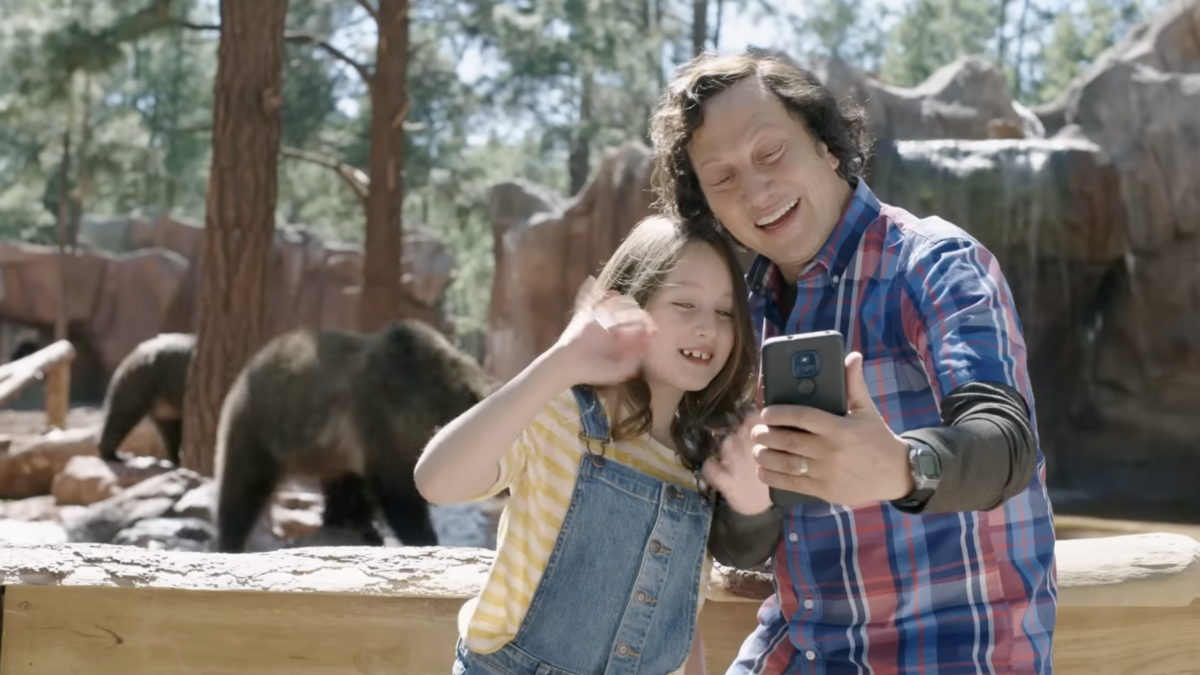 Father and daughter taking a selfie in front of bears