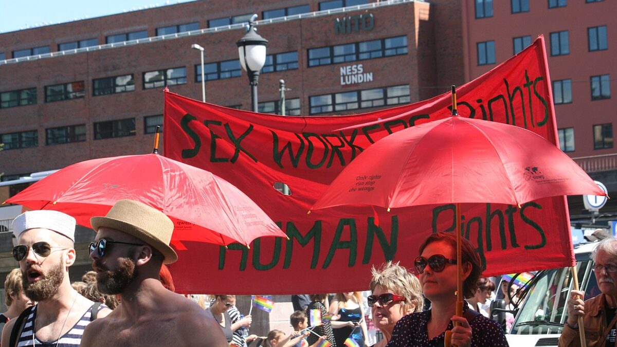 sex worker protesters carrying large red sign