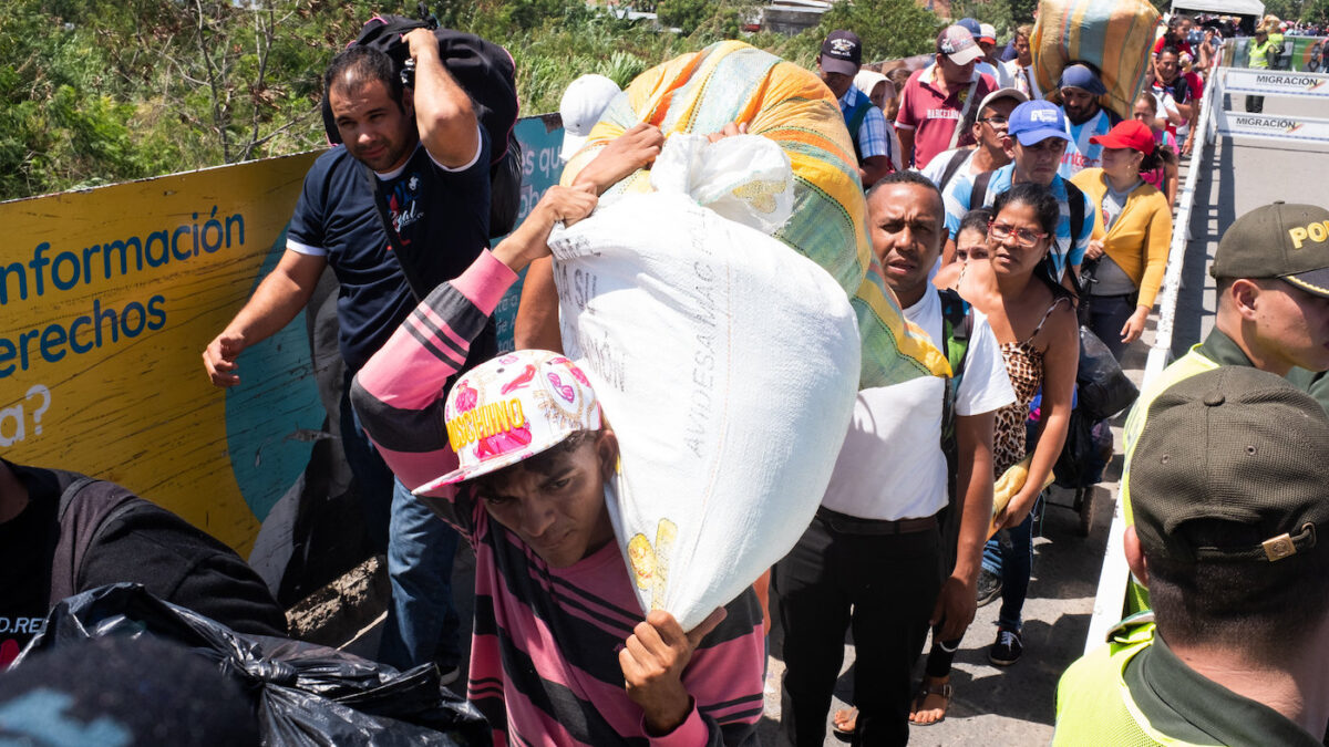 venezuelan migrants carrying bags of belongings