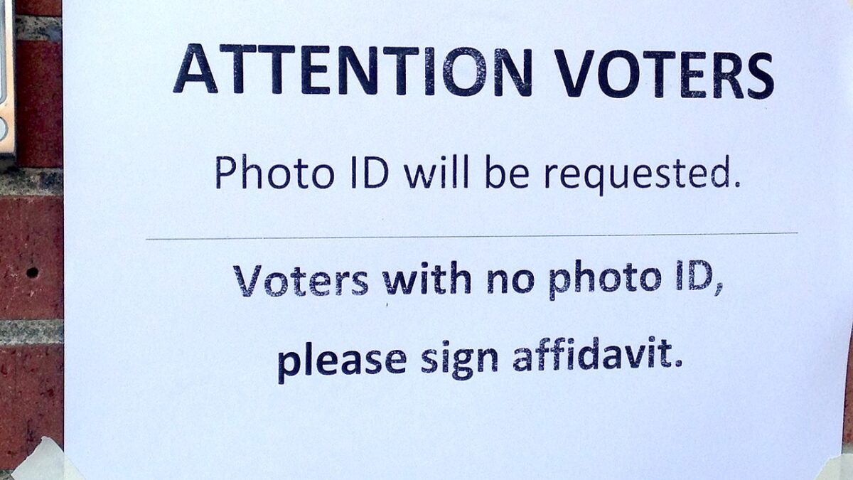 Voter ID sign taped to a wall