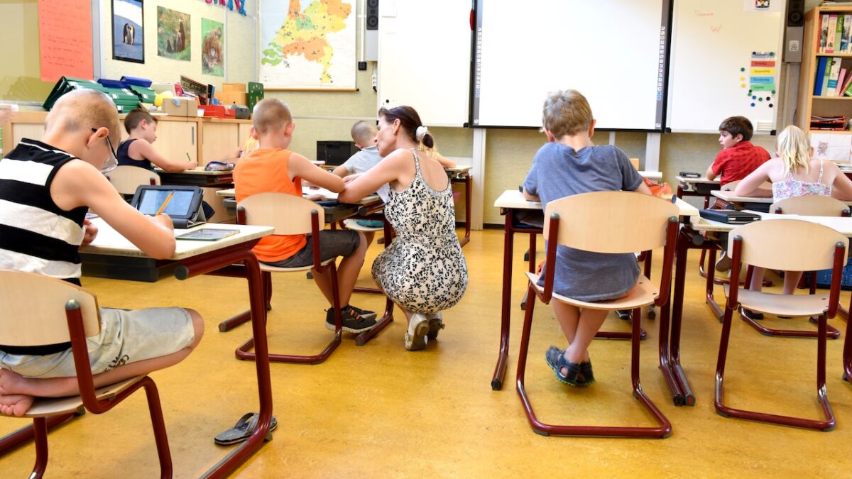 elementary classroom with students sitting at desks and teacher